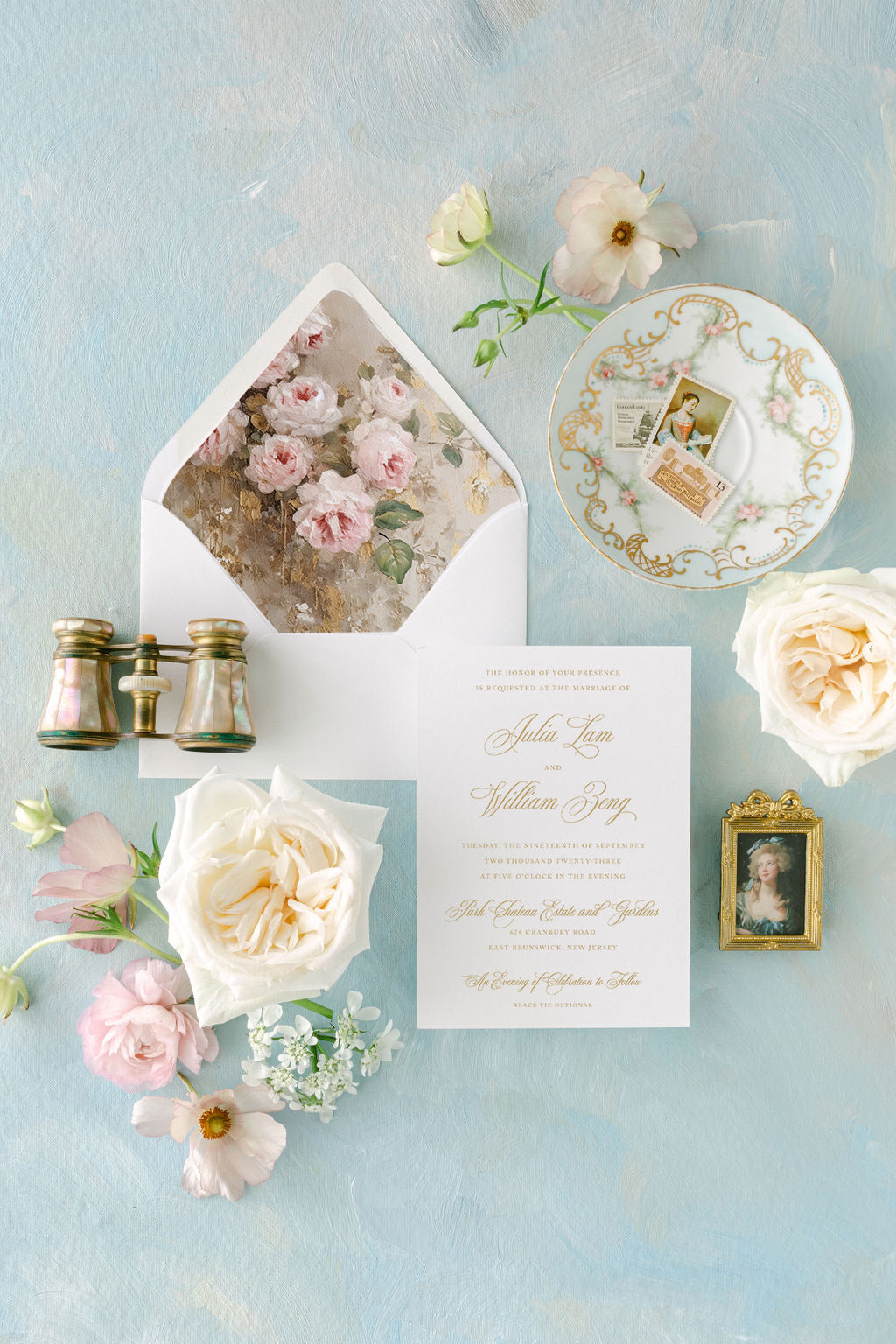 An elegant wedding invitation of the Julia Suite displayed with floral patterns and gold foil details, accompanied by a vintage-inspired floral envelope.